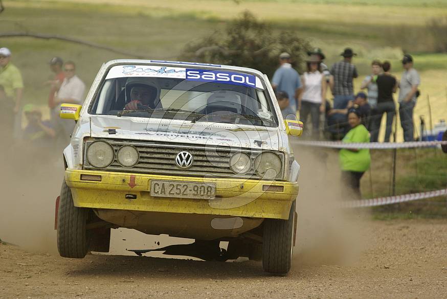 Front view of yellow volkswagen on a dirt road in a rally