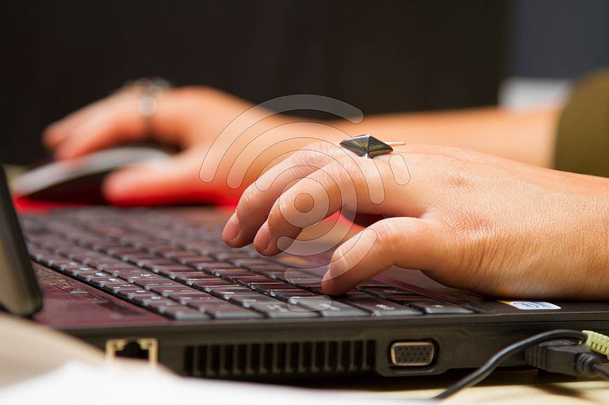 Woman's hands typing on a keyboard